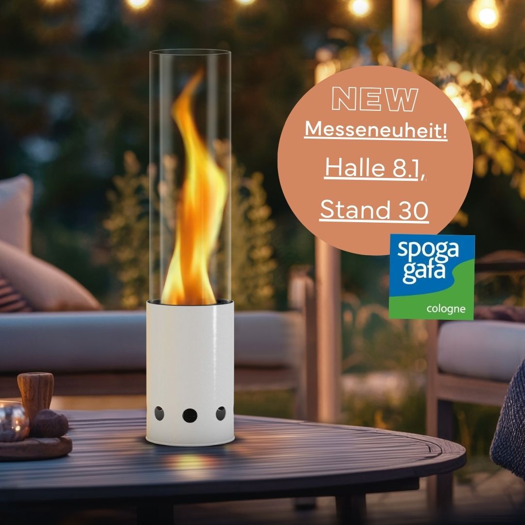 Weißes Tischfeuer von Gardenflare auf rundem Holztisch bei Abendstimmung und Hinweis auf spoga+gafa-Messe in Halle 8.1, Stand 30.
