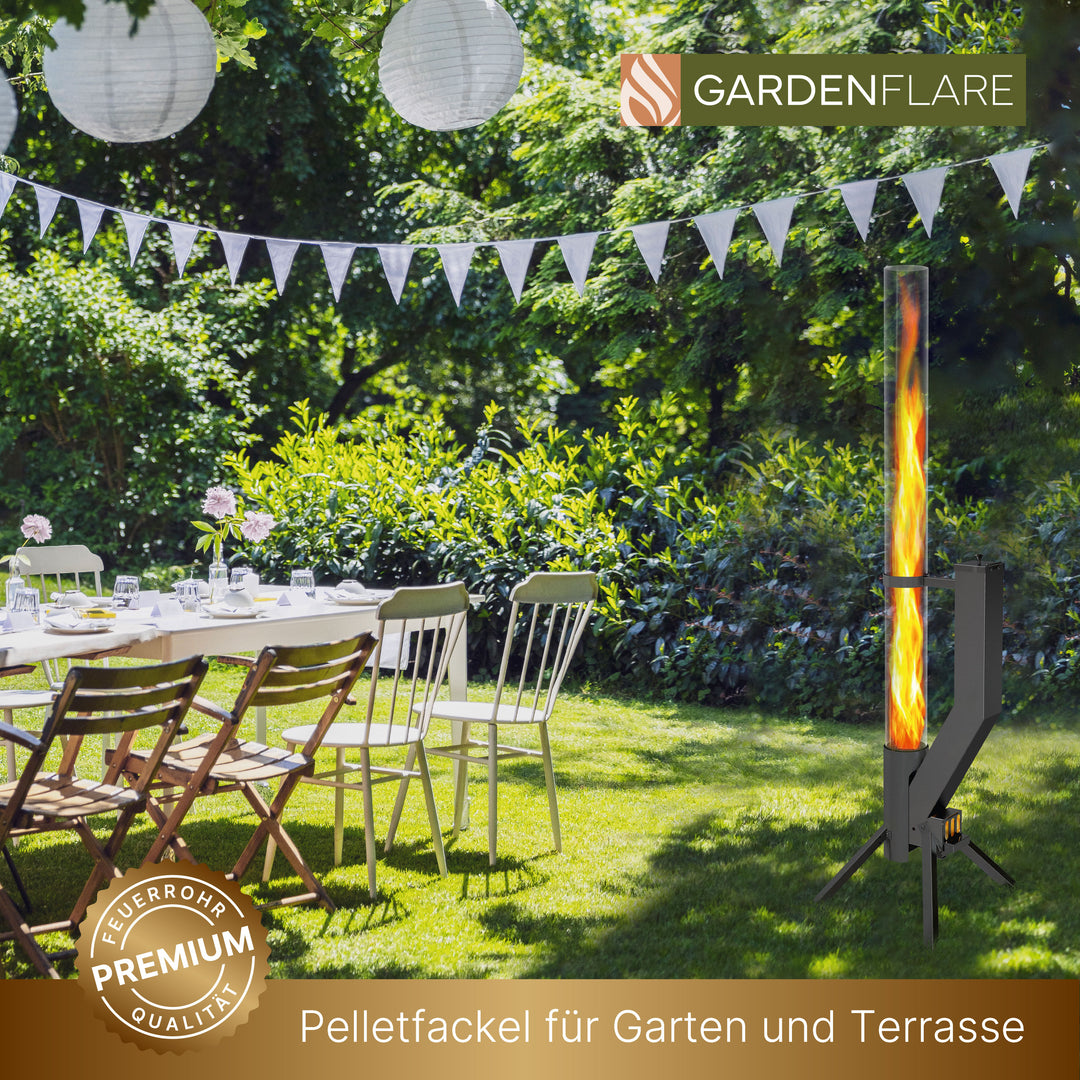 Feuerrohr PREMIUM in schwarz brennend neben festlich gedecktem Gartentisch unter Lampions. Perfekte Pelletfackel für Gartenpartys, Terrasse und Outdoor-Events.
