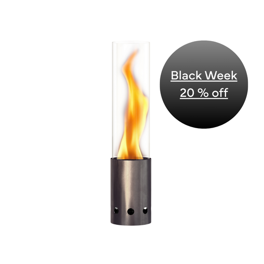 Tischfeuer mit Metallfuß aus hellem Edelstahl mit Flamme im Glaszylinder, daneben ein schwarzer Kreis mit „Black Week – 20 % off“.