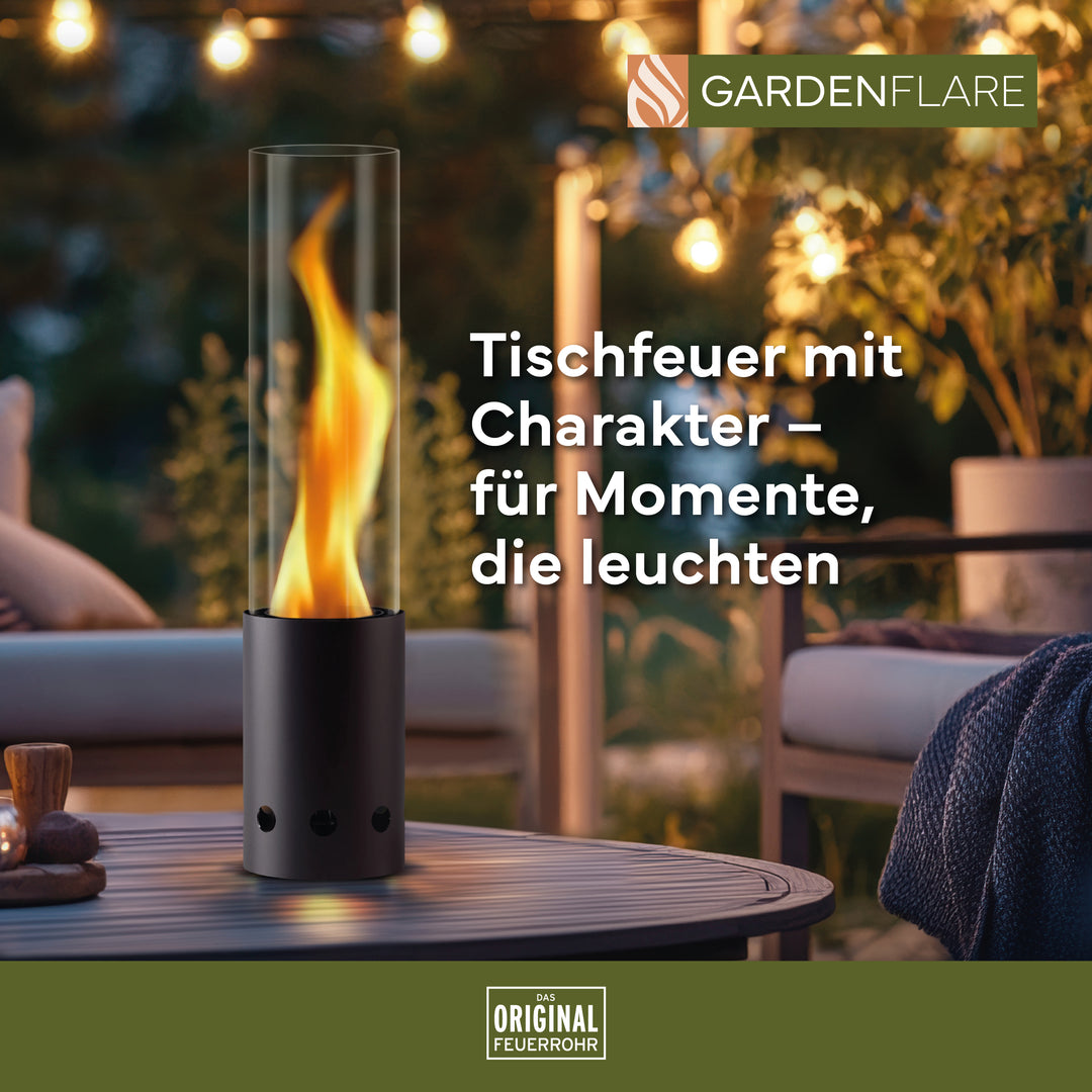 Gardenflare Tischfeuer schwarz mit Flamme auf Gartentisch – stimmungsvolles Licht bei Abenddämmerung, Text: Tischfeuer mit Charakter – für Momente, die leuchten