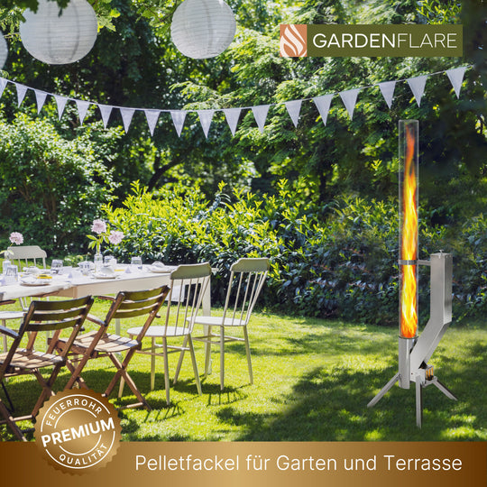 Feuerrohr PREMIUM in silber brennend neben einem gedeckten Gartentisch unter Lampions, mit Text „Pelletfackel für Garten und Terrasse“ und Gardenflare-Logo.