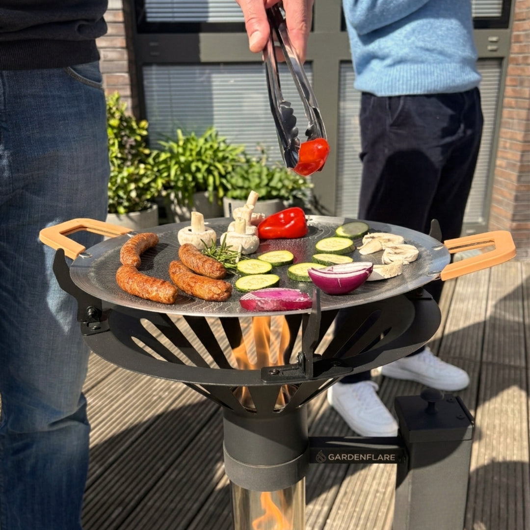 Gardenflare Grillaufsatz mit Grillpfanne auf Klassik Feuerrohr beim Grillen von Gemüse und Würstchen im Außenbereich
