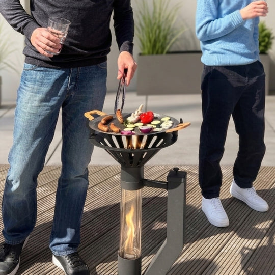 Gardenflare Grillaufsatz mit Grillpfanne auf Klassik Feuerrohr beim gemeinsamen Grillen im Außenbereich