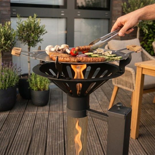 Gardenflare Grillaufsatz mit Grillpfanne auf Klassik Feuerrohr beim Grillen von Würstchen und Gemüse auf der Terrasse