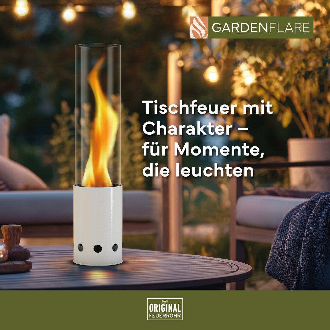 Gardenflare Tischfeuer weiss mit Flamme auf Gartentisch – stimmungsvolles Licht bei Abenddämmerung, Text: Tischfeuer mit Charakter – für Momente, die leuchten