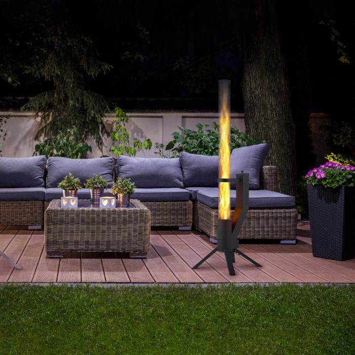 Garten-Sitzbereich mit grauem Sofa-Set und moderner Fackel im Vordergrund, beleuchtet in der Nacht.