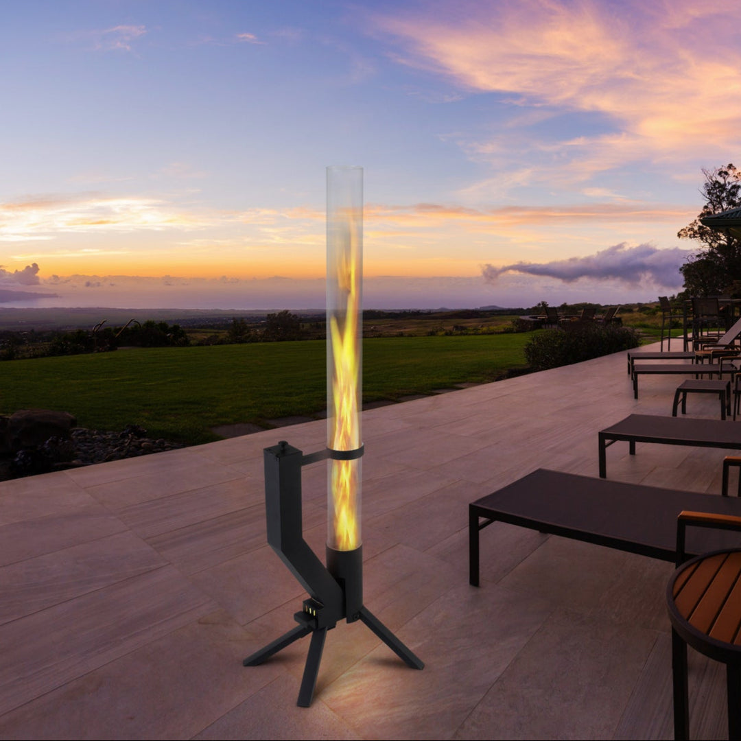 Ein Feuerrohr auf einer modernen Terrasse mit Lounge-Stühlen bei Sonnenuntergang, mit Blick auf eine weite Landschaft und einen farbenfrohen Himmel.
